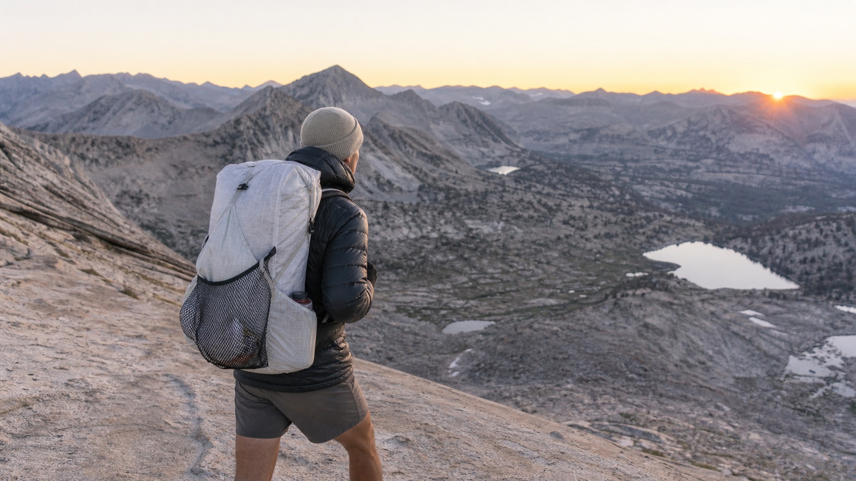 Hiker carrying lightweight equipment above an alpine valley